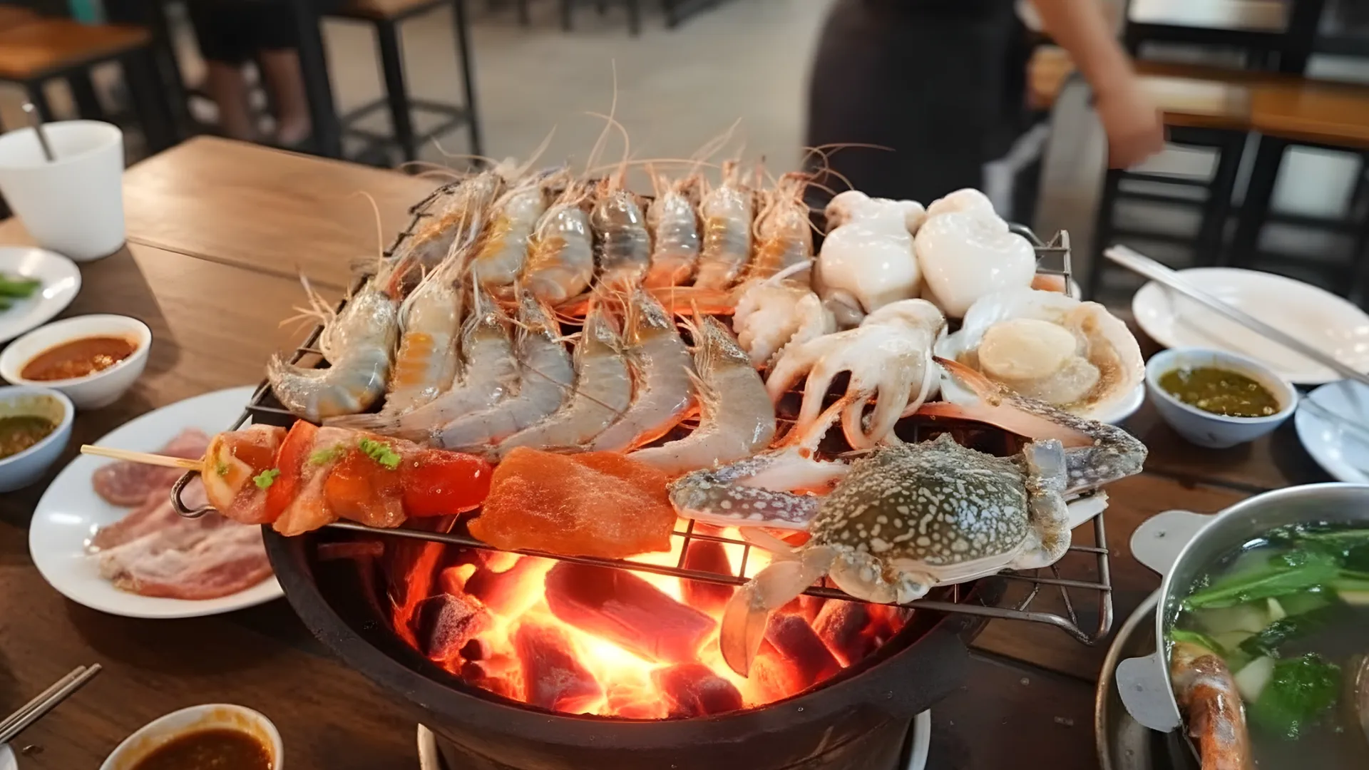 อาหารทะเลสดใหม่กำลังถูกย่างบนเตาถ่านในร้านหมูกระทะ สะท้อนถึงการสร้างมูลค่าเพิ่มให้ธุรกิจร้านอาหาร